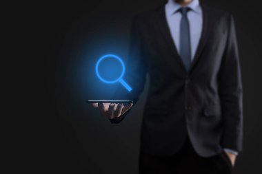 İş adamı ve adam el ele tutuşup cam ikonunu büyütüyorlar. İş dünyası, teknoloji ve internet kavramı