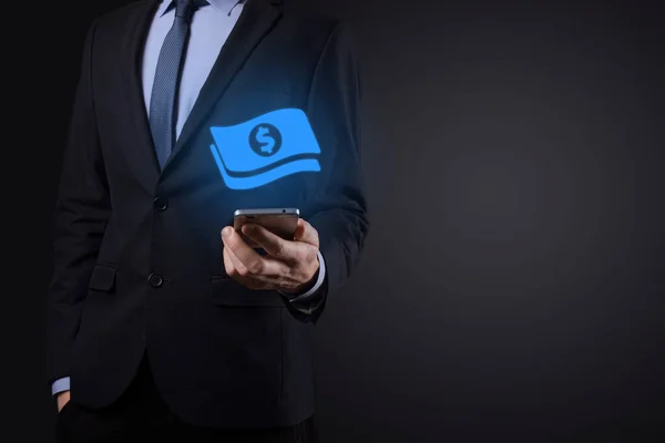 Businessman man holding money coin icon in his hands.Growing money concept for business investment and finance. USD or US dollar on dark tone background.