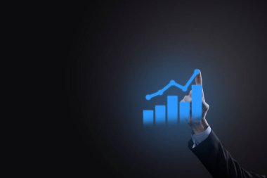 İş adamı elinde tablet tutuyor ve karanlık zemin üzerinde ok bulunan istatistik, grafik ve grafiklerin büyüyen sanal hologramını gösteriyor. Borsa. İş büyümesi, planlama ve strateji kavramı