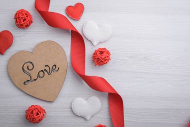 Sevgililer Günü tebrik kartı için arka plan. Sevgililer günü konsepti. Kırmızı hediye kurdeleleri, hediyeler, ahşap bir arka planda kalpler. Üst görünüm.