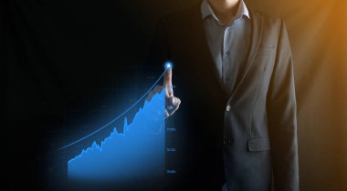 Holografik grafikler ve borsa istatistikleri tutan işadamı kâr elde ediyor. Büyüme planlama ve iş stratejisi kavramı. İyi ekonomi formunun dijital ekran görüntüsü