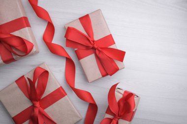 Sevgililer Günü tebrik kartı için arka plan. Sevgililer günü konsepti. Kırmızı hediye kurdeleleri, hediyeler, ahşap bir arka planda kalpler. Üst görünüm.