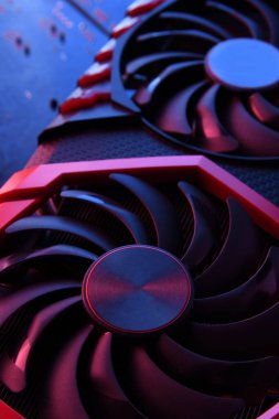 Bilgisayar oyunu grafikleri kartı, devre kartında iki soğutucu olan video oyunu, anakart geçmişi. Yakın plan. Kırmızı-mavi bir ışıkla.