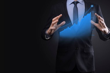 Holografik grafikler ve borsa istatistikleri tutan işadamı kâr elde ediyor. Büyüme planlama ve iş stratejisi kavramı. İyi ekonomi formunun dijital ekran görüntüsü