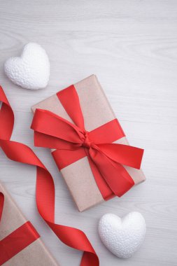 Sevgililer Günü tebrik kartı için arka plan. Sevgililer günü konsepti. Kırmızı hediye kurdeleleri, hediyeler, ahşap bir arka planda kalpler. Üst görünüm.