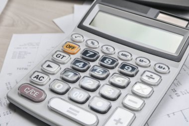Masadaki faturaları hesaplamak için hesap makinesi ve mal ve hizmetlerin çeklerini içeren faturalar. Maliyetlerin hesaplanması.