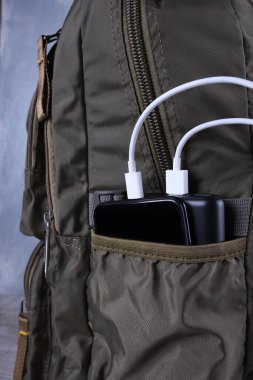 Telefon şarjı, elektrik faturası akıllı telefon, enerji bankasıyla cep telefonu. Sırt çantasındaki Güç Bankası 'nın derinliği