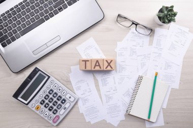 Masadaki faturaları hesaplamak için hesap makinesi ve mal ve hizmetlerin çeklerini içeren faturalar. Maliyetlerin hesaplanması.