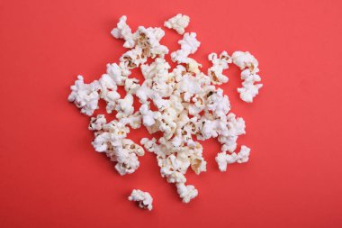 Kırmızı arkaplanda patlamış mısır. Üst görünümü kapat.