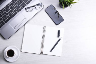 Bilgisayarlı masa masası, akıllı telefon, bir fincan kahve ve malzeme, ahşap arka planda. Kopyalama alanı olan üst görünüm, düz yatay