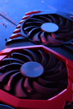 Bilgisayar oyunu grafikleri kartı, devre kartında iki soğutucu olan video oyunu, anakart geçmişi. Yakın plan. Kırmızı-mavi ışıkla.