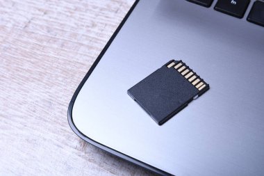 Tahta masadaki dizüstü bilgisayarda mikro SD hafıza kartı adaptörü. Kapat.