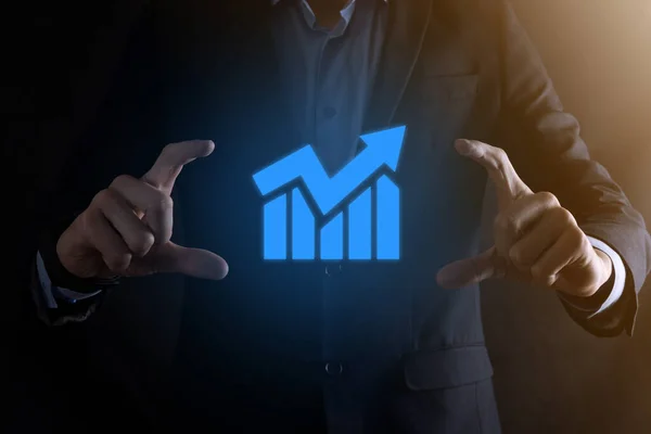Businessman man holding a graph with positive profits growth. plan graph growth and increase of chart positive indicators in his business.more profitable and growing