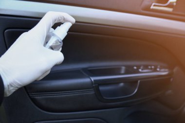 Arabanın içini temizlemek ve dezenfeksiyon sıvısı sıkmak. Direksiyon ve direksiyon kollarında dezenfeksiyon var. Coronavirus koruması. Virüs koruması. Vihicle içeriden dezenfekte ediliyor.