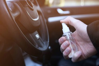 Arabanın içini temizlemek ve dezenfeksiyon sıvısı sıkmak. Direksiyon ve direksiyon kollarında dezenfeksiyon var. Coronavirus koruması. Virüs koruması. Vihicle içeriden dezenfekte ediliyor.