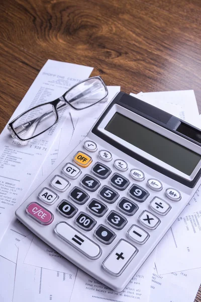 Calculator keypad with checks from the store from shopping on a wooden floor background. Top view. Copy space