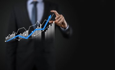 Holografik grafikler ve borsa istatistikleri tutan işadamı kâr elde ediyor. Büyüme planlama ve iş stratejisi kavramı. İyi ekonomi formunun dijital ekran görüntüsü
