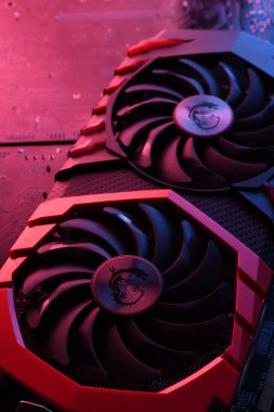 Bilgisayar oyunu grafikleri kartı, devre kartında iki soğutucu olan video oyunu, anakart geçmişi. Yakın plan. Kırmızı-mavi ışıkla.