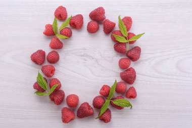 Ahşap bir arka planda ahududulardan oluşan daire.