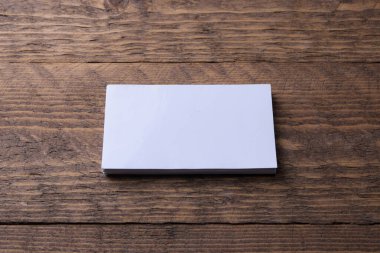 Tahta arka planda kartvizit boş. Şirket kırtasiyesi, markalaşma modeli. Yaratıcı tasarımcı masası. Düz yatıyordu. Uzayı metin için kopyala. Kimlik Şablonu