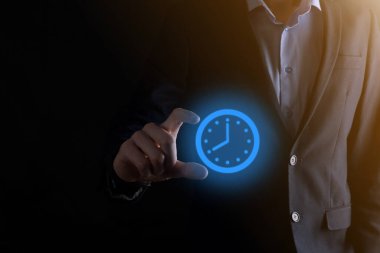 İş adamı, saatin simgesini okla tutar. İşlerin hızlı yürütülmesi. İş zamanı yönetimi ve iş zamanı para kavramlarıdır..