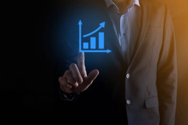 İş adamı elinde pozitif kar artışı olan bir grafik tutuyor. Grafik büyümesi ve grafik artışı işlerinde olumlu göstergeler. Daha kârlı ve büyüyen