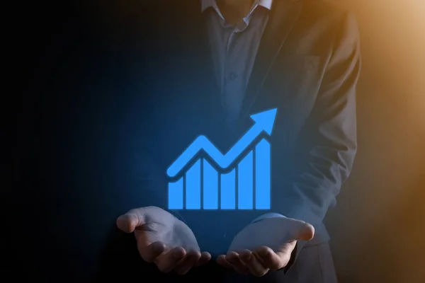 Businessman man holding a graph with positive profits growth. plan graph growth and increase of chart positive indicators in his business.more profitable and growing