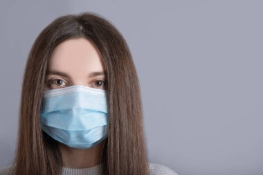 Kadın, kız, ergen portresi, hoş, çekici, sevimli, sevimli, uzun siyah saçlı, beyaz kazak giyen, gripli, soğuk yüz maskesi takan,...