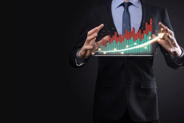 Businessman on a black background presses, presses a finger on a positive growth arrow. Graphs of indicators. Business development and finance concept.