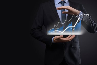 Siyah arka plan baskısı yapan bir iş adamı, pozitif büyüme okuna parmağını basar. Göstergelerin grafikleri. İş geliştirme ve finans kavramı.