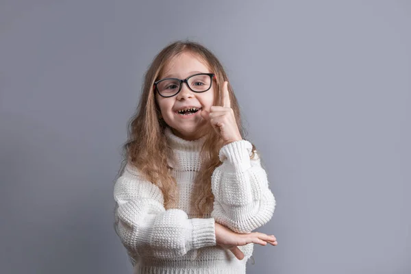 Portret Młodej Atrakcyjnej Dziewczynki Blond Włosami Białym Swetrze Uśmiechniętym Wskazującym — Zdjęcie stockowe