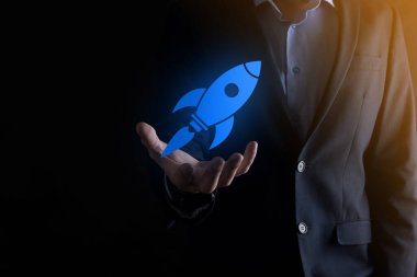 Soyut dijital roket ikonu taşıyan iş adamı konsepti fırlatılıyor ve yükseliyor.