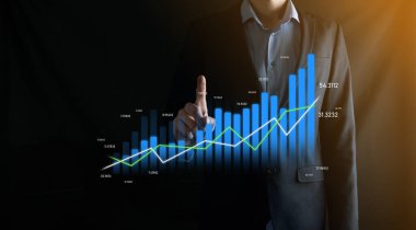 İş adamı holografik grafikler ve borsa istatistikleri tutuyor ve gösteriyor. Büyüme planlama ve iş stratejisi kavramı. İyi ekonomi formunun dijital ekran görüntüsü