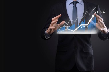 Holografik grafikler ve borsa istatistikleri tutan işadamı kâr elde ediyor. Büyüme planlama ve iş stratejisi kavramı. İyi ekonomi formunun dijital ekran görüntüsü