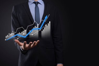 Holografik grafikler ve borsa istatistikleri tutan işadamı kâr elde ediyor. Büyüme planlama ve iş stratejisi kavramı. İyi ekonomi formunun dijital ekran görüntüsü