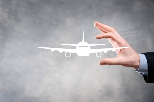 Businessman holding an airplane icon in his hands. Online ticket purchase.Travel.