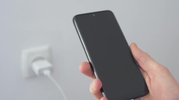 Ricarica Carica Cellulare Smartphone Uomo Tiene Mano Cellulare Uno Sfondo — Video Stock