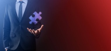 İki şirketin birleşmesini veya ortak girişim, ortaklık, birleşme ve satın alma kavramını temsil eden bulmaca parçalarını birleştiren işadamı elleri.