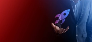 Soyut dijital roket ikonu taşıyan iş adamı konsepti fırlatılıyor ve yükseliyor