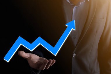 İş adamı artan ekran grafiği, pozitif büyüme ikonu okları üzerinde duruyor. Yaratıcı iş grafiğine yükselen oklarla işaret ediyor. Finansal, ticari büyüme kavramı.
