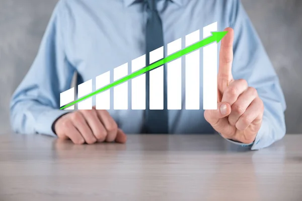 Businessman man holding a graph with positive profits growth. plan graph growth and increase of chart positive indicators in his business.more profitable and growing.