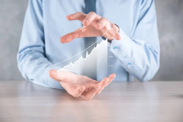 Businessman man holding a graph with positive profits growth. plan graph growth and increase of chart positive indicators in his business.more profitable and growing.