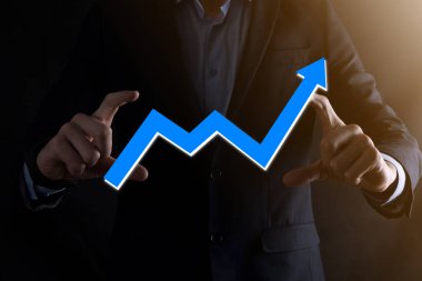 İş adamı artan ekran grafiği, pozitif büyüme ikonu okları üzerinde duruyor. Yaratıcı iş grafiğine yükselen oklarla işaret ediyor. Finansal, ticari büyüme kavramı.