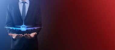 İş adamı elinde bir uçak ikonunu tutuyor. Online bilet alımı. Seyahat planlama, ulaşım, otel, uçuş ve pasaport ikonları. Uçuş biletleri konsepti.