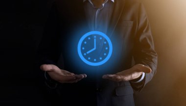 İş adamı, saatin simgesini okla tutar. İşlerin hızlı yürütülmesi. İş zamanı yönetimi ve iş zamanı para kavramlarıdır..