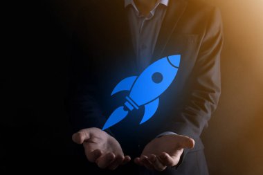 Soyut dijital roket ikonu taşıyan iş adamı konsepti fırlatılıyor ve yükseliyor.