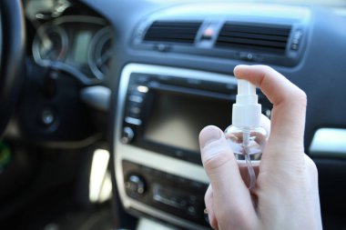 Arabanın içini temizlemek ve dezenfeksiyon sıvısı sıkmak. Direksiyon ve direksiyon kollarında dezenfeksiyon var. Coronavirus koruması. Virüs koruması. Vihicle içeriden dezenfekte ediliyor.