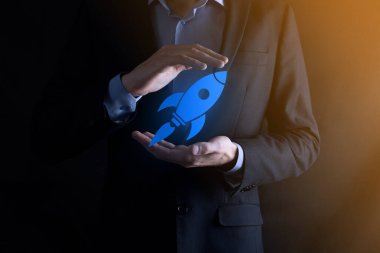 Soyut dijital roket ikonu taşıyan iş adamı konsepti fırlatılıyor ve yükseliyor.