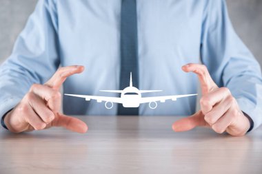 İş adamı elinde bir uçak ikonu tutuyor. Online bilet alımı. Seyahat..