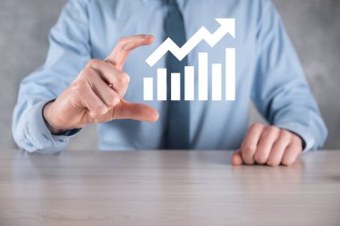 İş adamı elinde pozitif kar artışı olan bir grafik tutuyor. Grafik büyümesi ve grafik artışı işlerinde olumlu göstergeler. Daha kârlı ve büyüyen